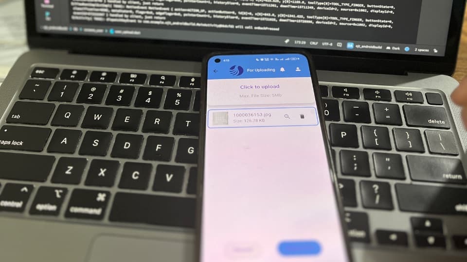 The transaction tracking app running on an Android device in front of the Flutter project in Android Studio